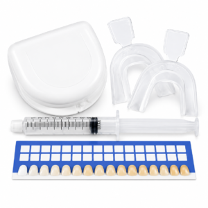 Professional teeth whitening kit with white storage case, clear mouth trays, gel syringe and tooth shade guide