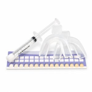 Clear whitening gel syringe beside transparent mouth trays and a purple and white teeth shade guide