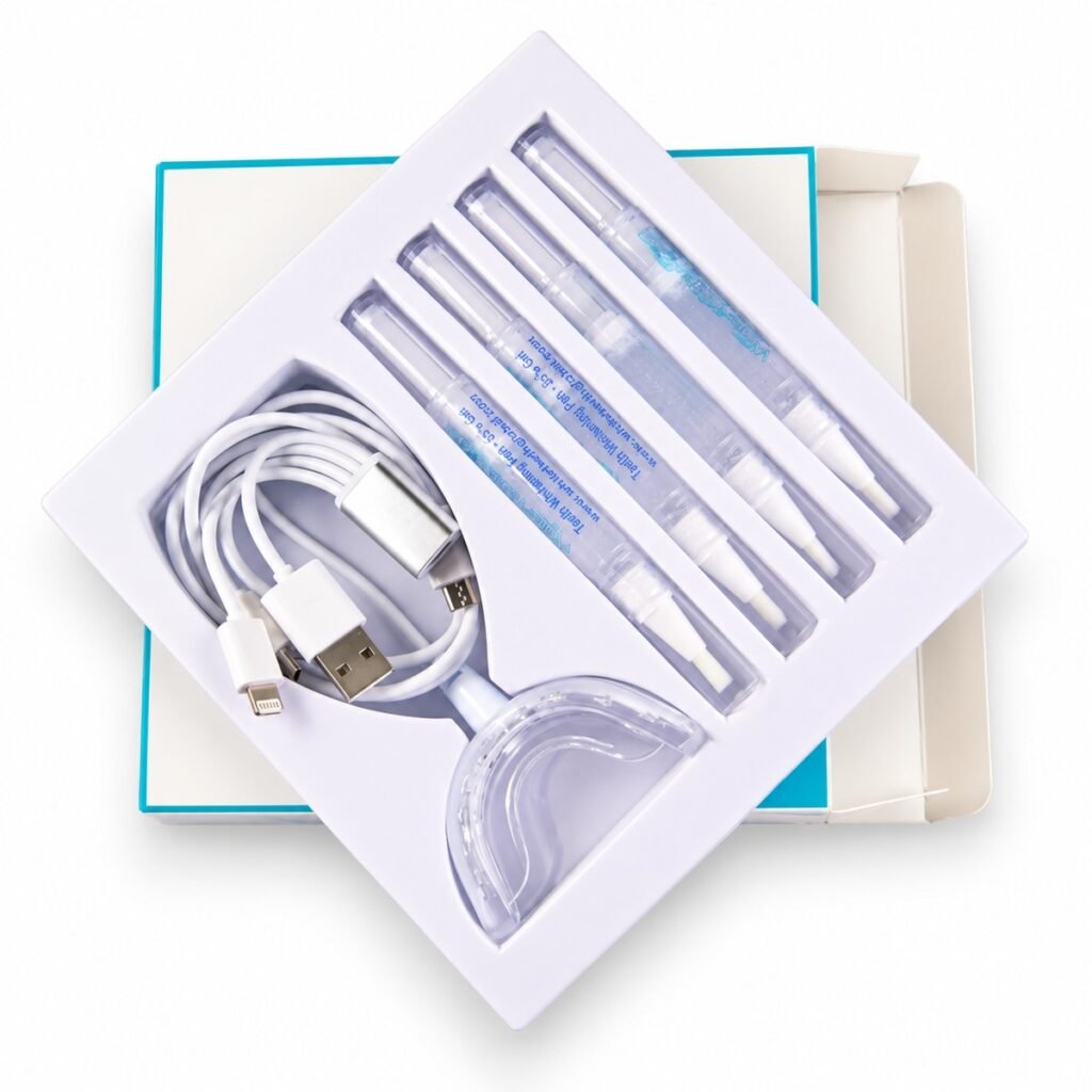Open white tray kit containing four whitening pens, an LED mouth tray and a multi-adapter USB cable